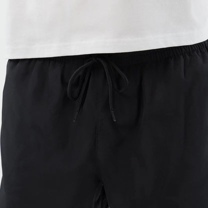 The model is wearing this New Era Swimming Shorts in black. 7