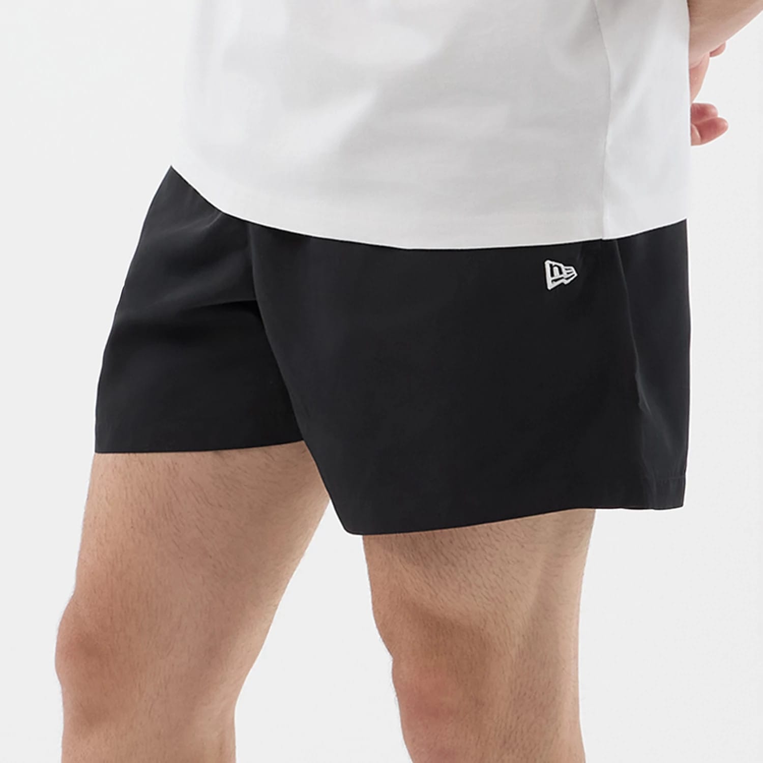 The model is wearing this New Era Swimming Shorts in black. 5