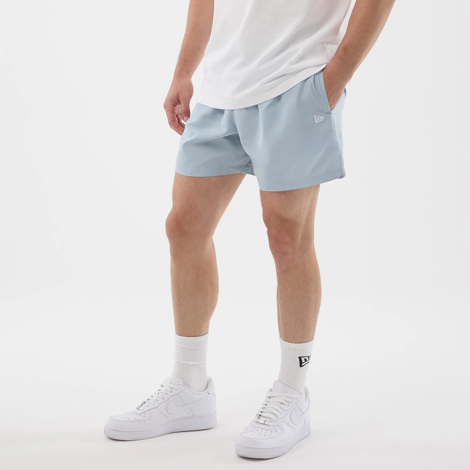 The model is wearing this New Era Swimming Shorts in pastel blue. 3