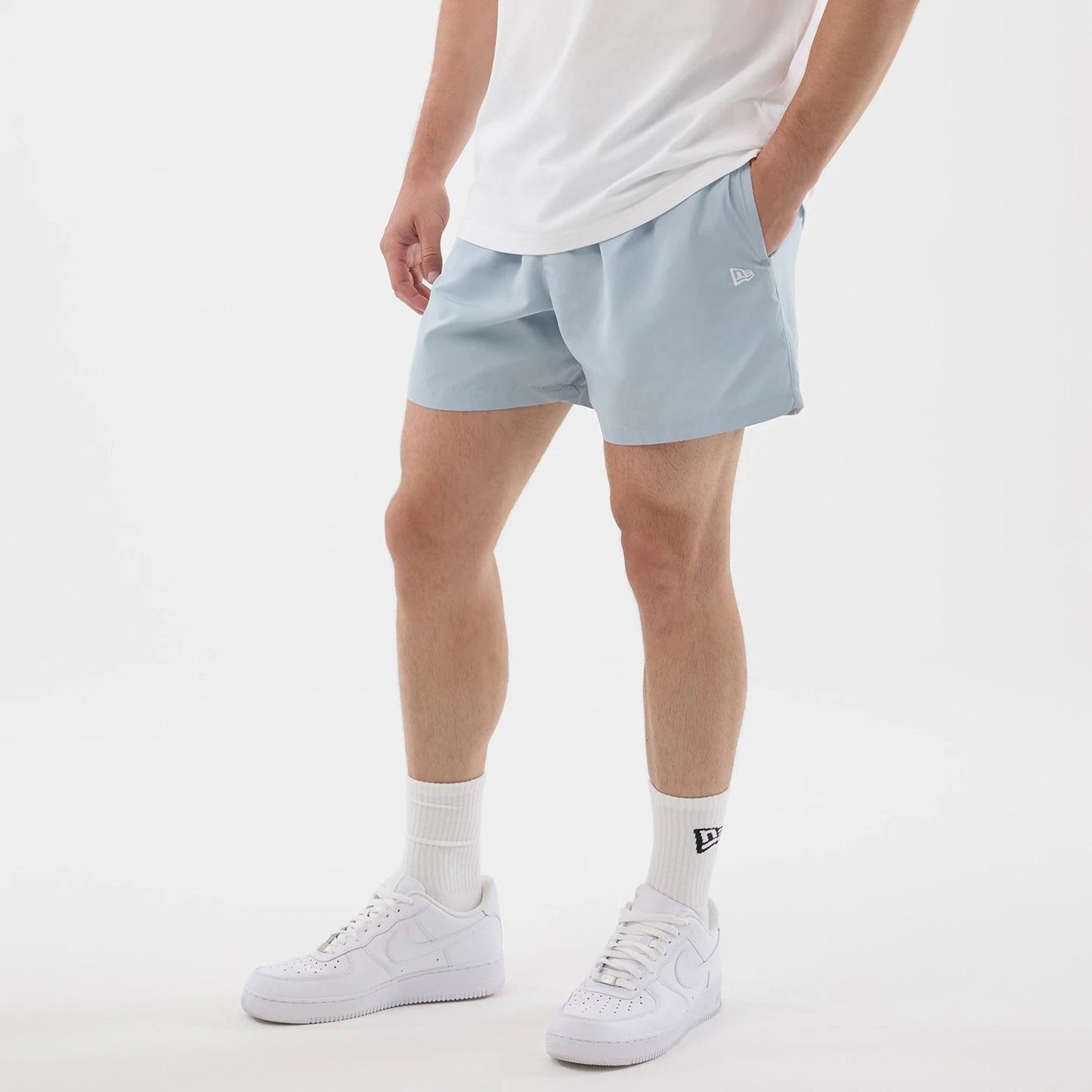 The model is wearing this New Era Swimming Shorts in pastel blue. 3