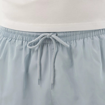 The model is wearing this New Era Swimming Shorts in pastel blue. 7