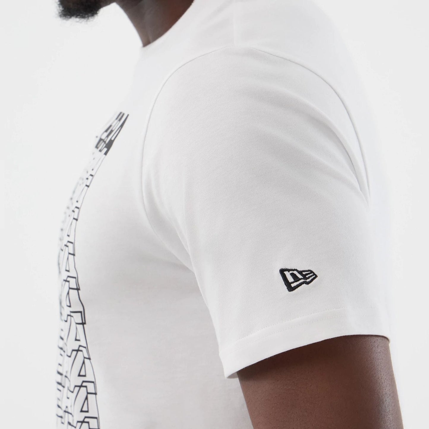 The model is wearing this New Era Logo Graphic T-Shirt in white. 5