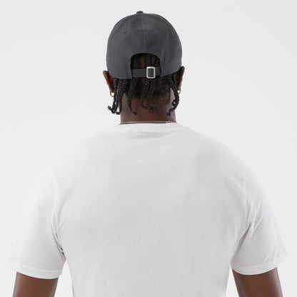 The model is wearing this New Era Logo Graphic T-Shirt in white. 7