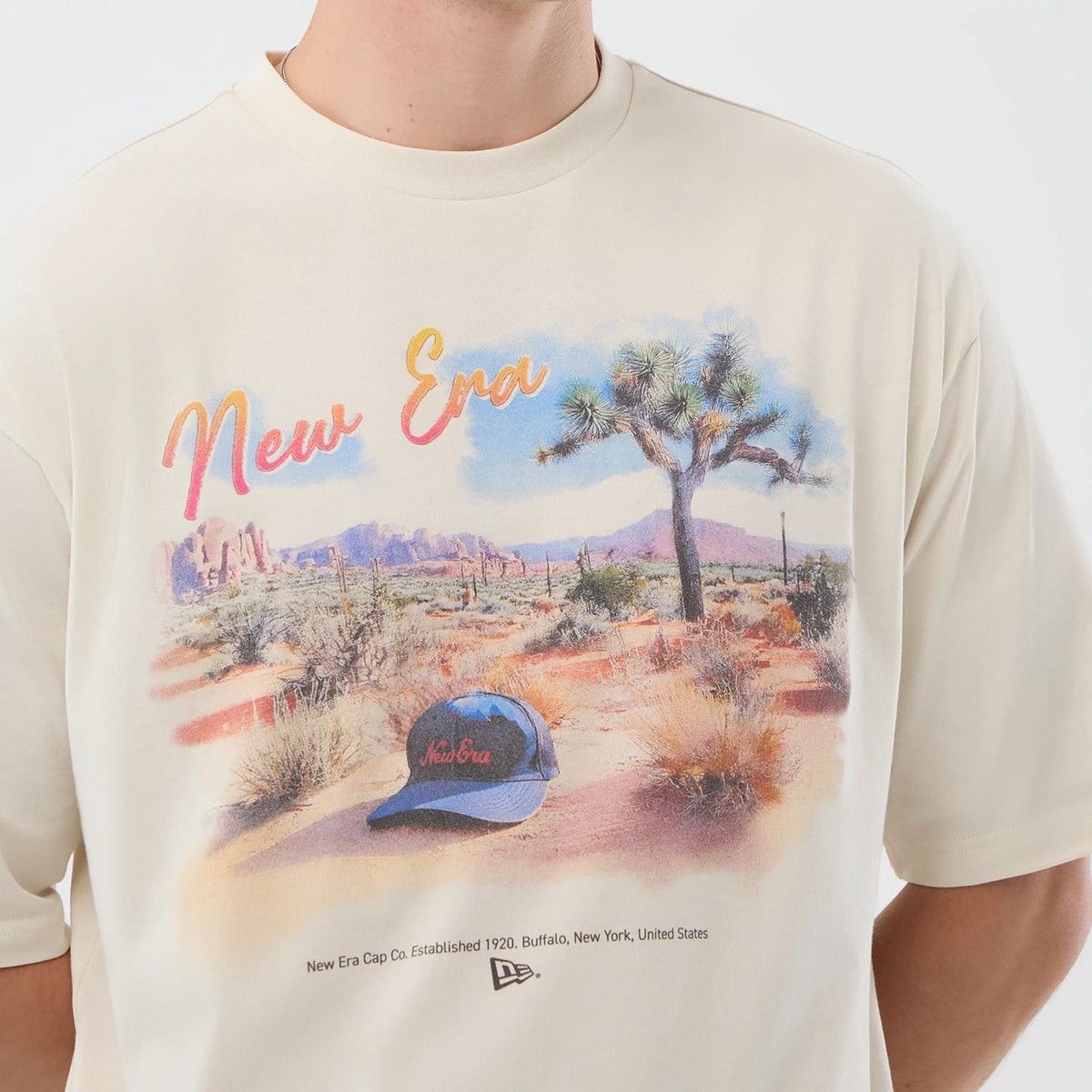 The model is wearing this New Era Dessert Graphic Oversized T-Shirt in light beige. 5