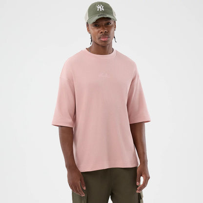 The model is wearing this New Era Waffle T-Shirt in pastel pink. 3