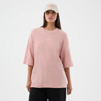 The model is wearing this New Era Waffle T-Shirt in pastel pink. 4