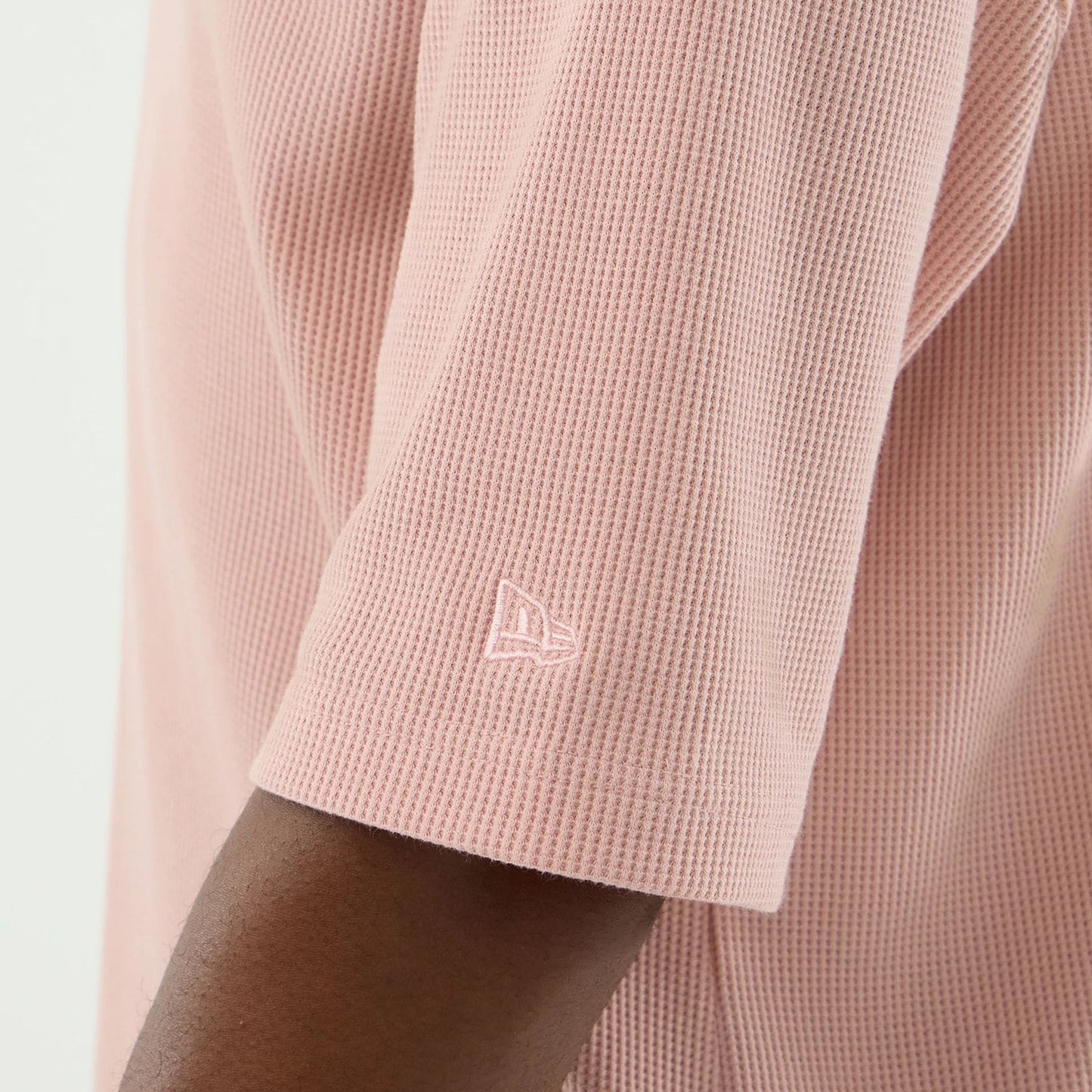 The model is wearing this New Era Waffle T-Shirt in pastel pink. 7