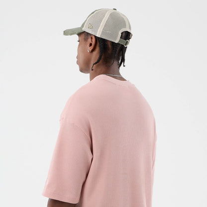 The model is wearing this New Era Waffle T-Shirt in pastel pink. 8