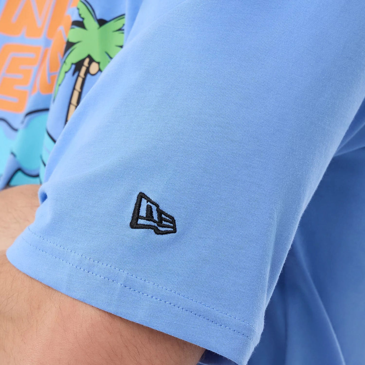 The model is wearing this New Era Basketball Character Graphic T-Shirt in pastel blue. 7