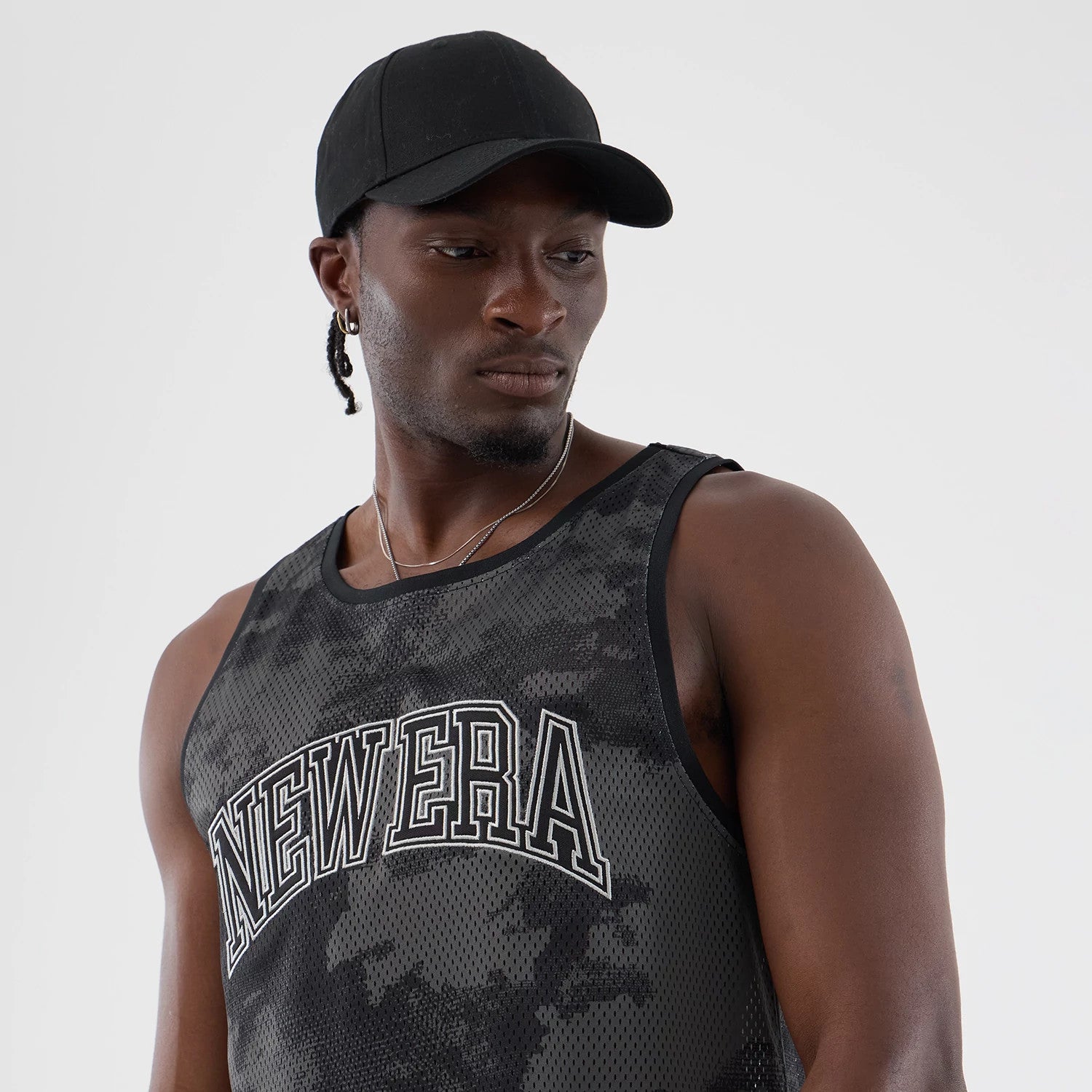 The model is wearing this New Era All Over Print Mesh Tank Top in black camo. 4