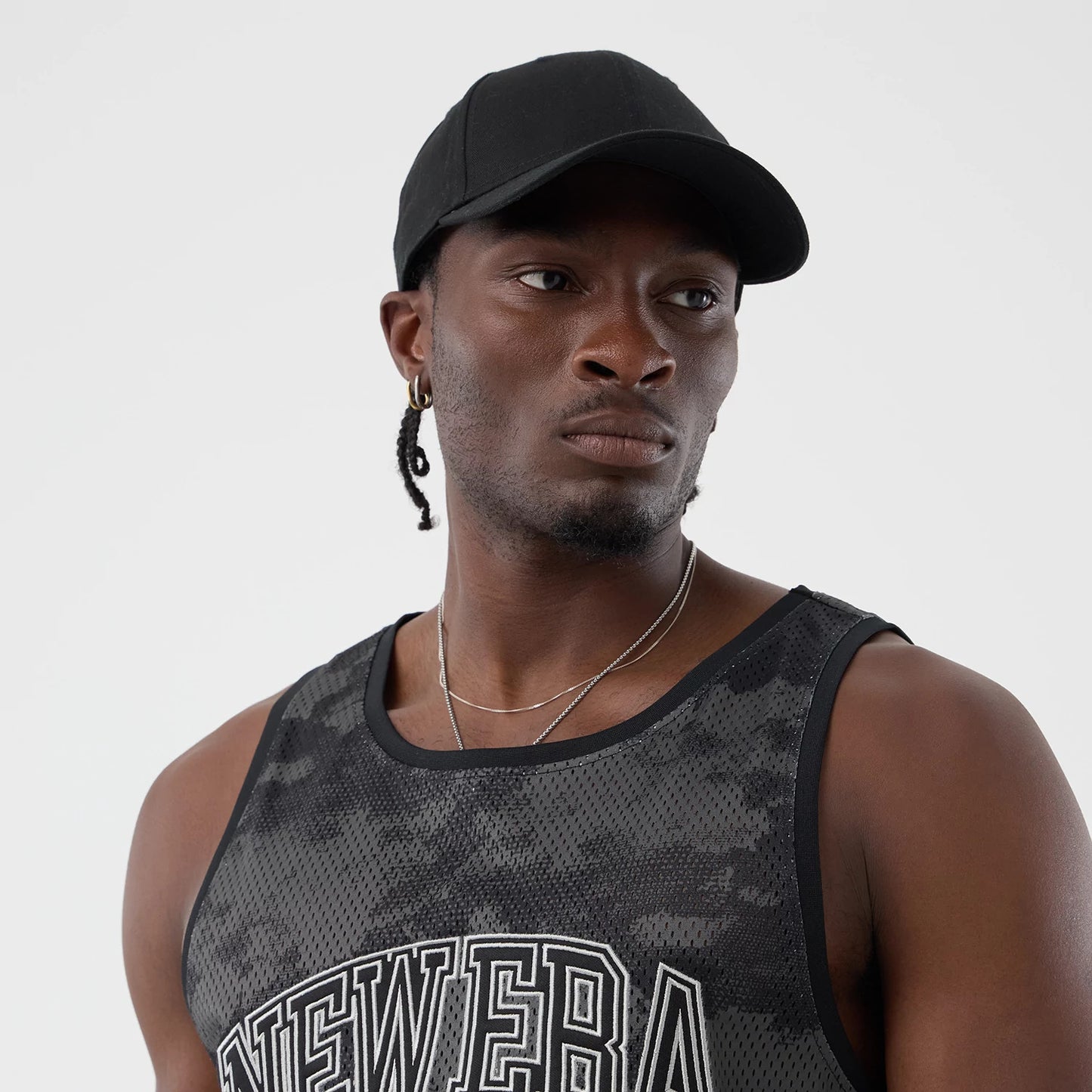 The model is wearing this New Era All Over Print Mesh Tank Top in black camo. 6