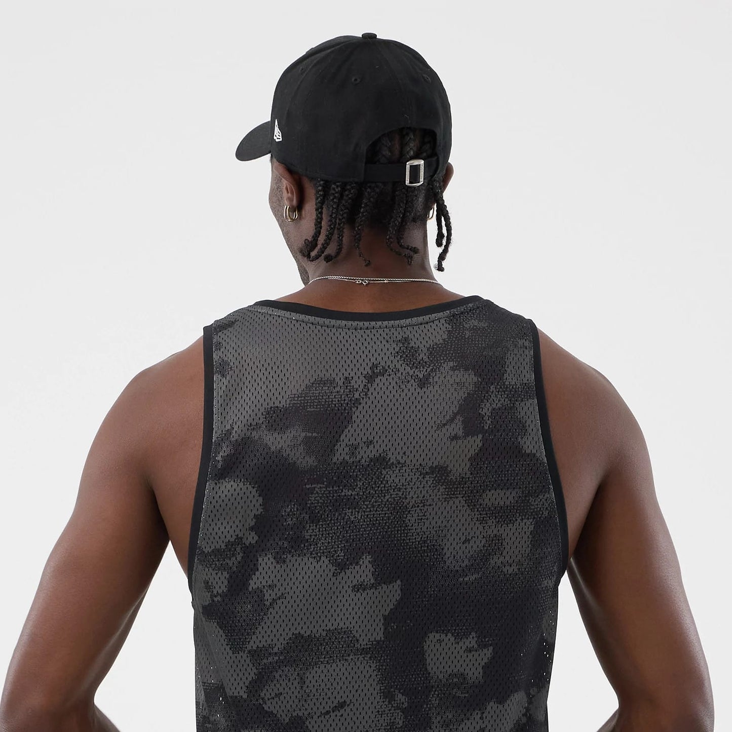 The model is wearing this New Era All Over Print Mesh Tank Top in black camo. 7