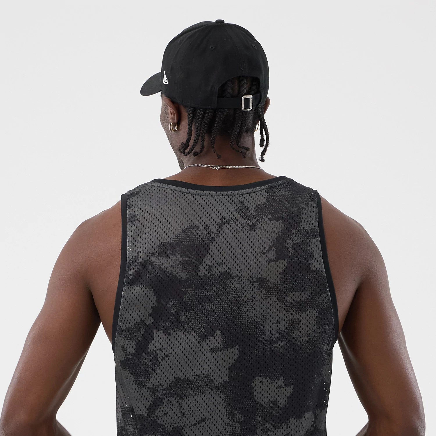 The model is wearing this New Era All Over Print Mesh Tank Top in black camo. 7