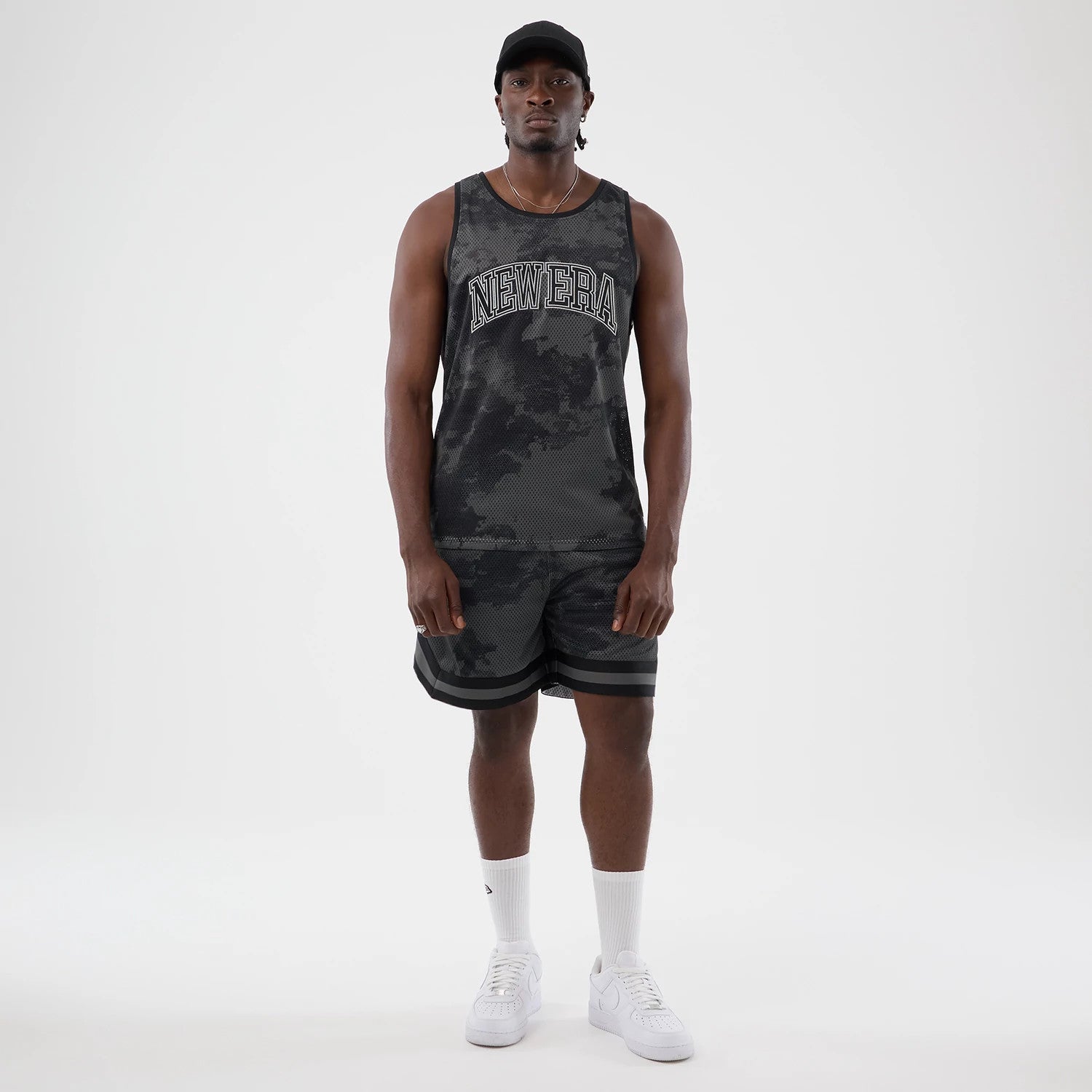 The model is wearing this New Era All Over Print Mesh Tank Top in black camo. 8