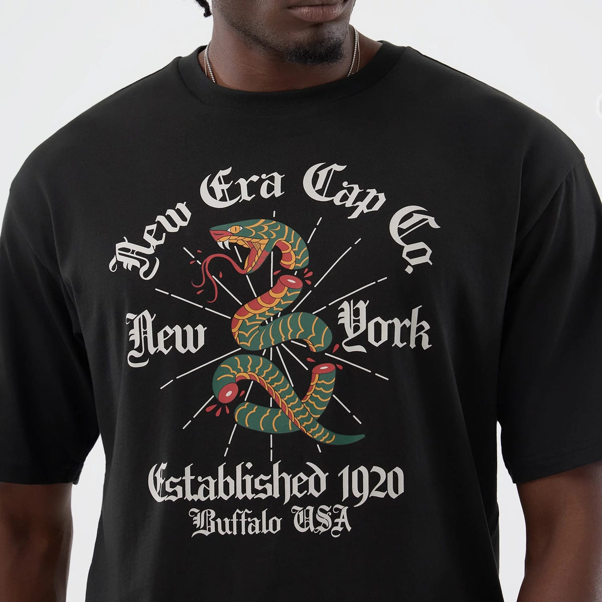 The model is wearing this New Era Serpent Graphic Oversized T-Shirt in black. 4