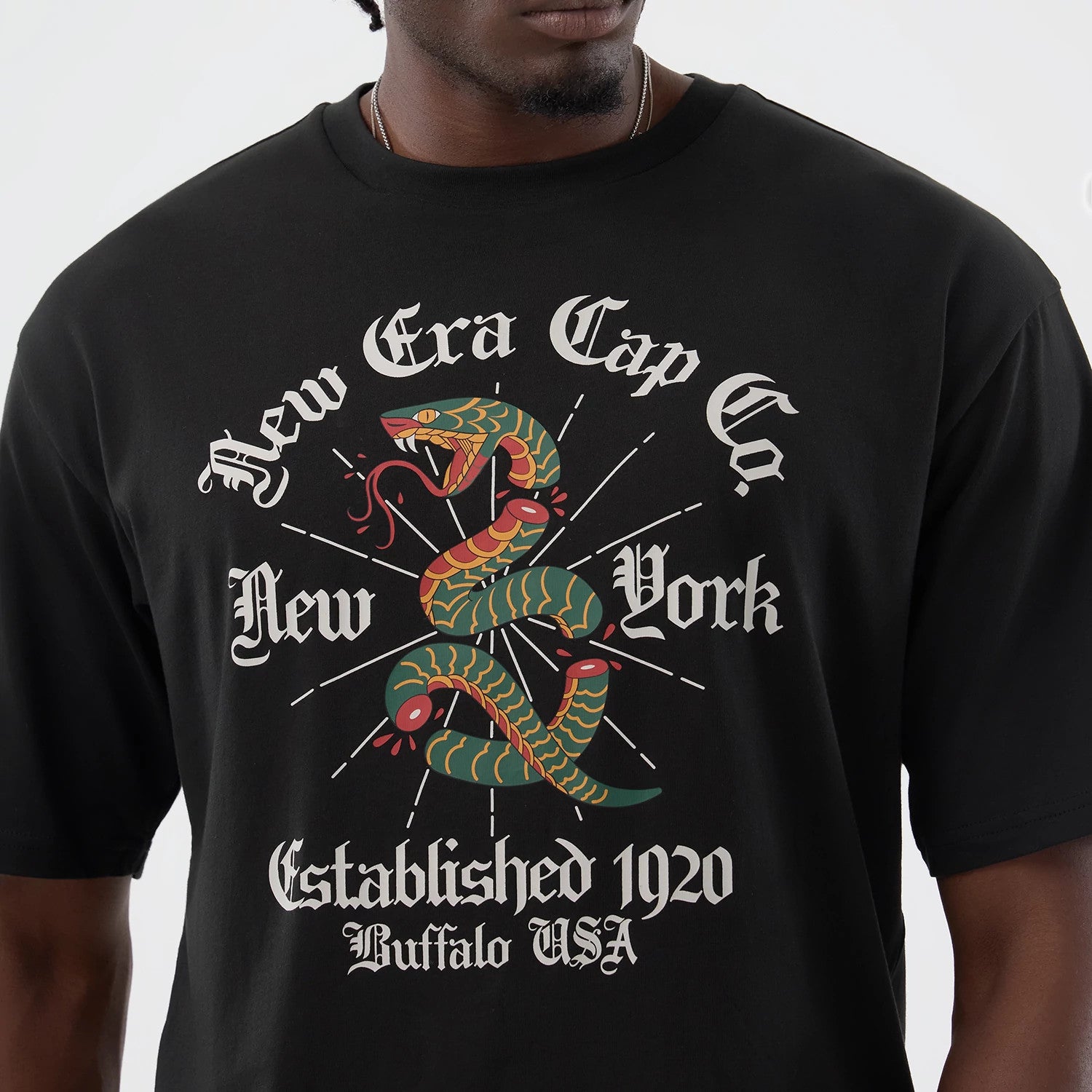 The model is wearing this New Era Serpent Graphic Oversized T-Shirt in black. 4