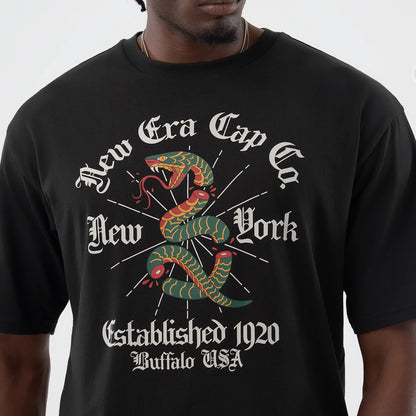 The model is wearing this New Era Serpent Graphic Oversized T-Shirt in black. 4