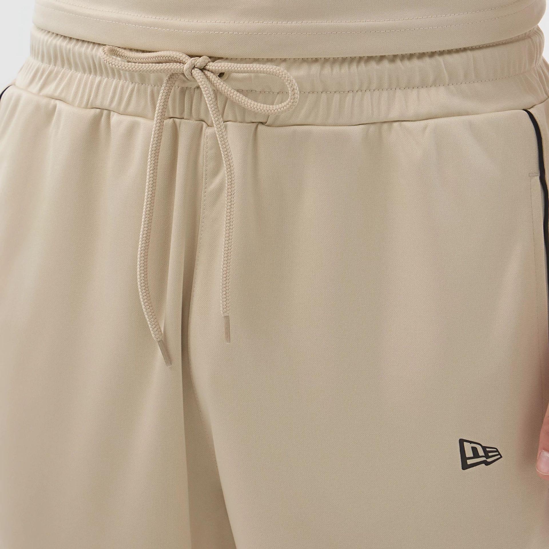 The model is wearing these New Era Football Shorts in light beige. 5