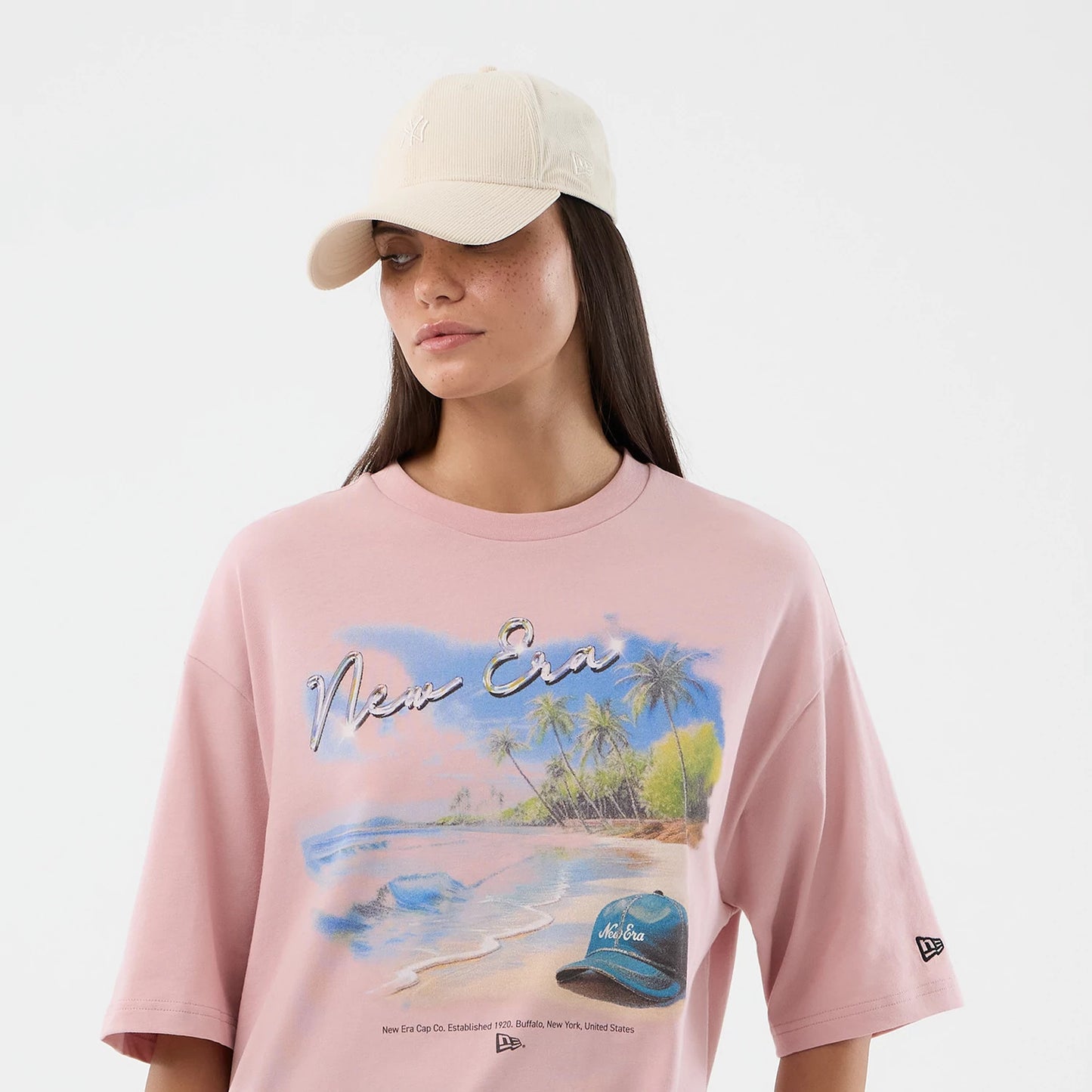The model is wearing this New Era Beach Graphic Oversized T-Shirt in pastel pink. 6