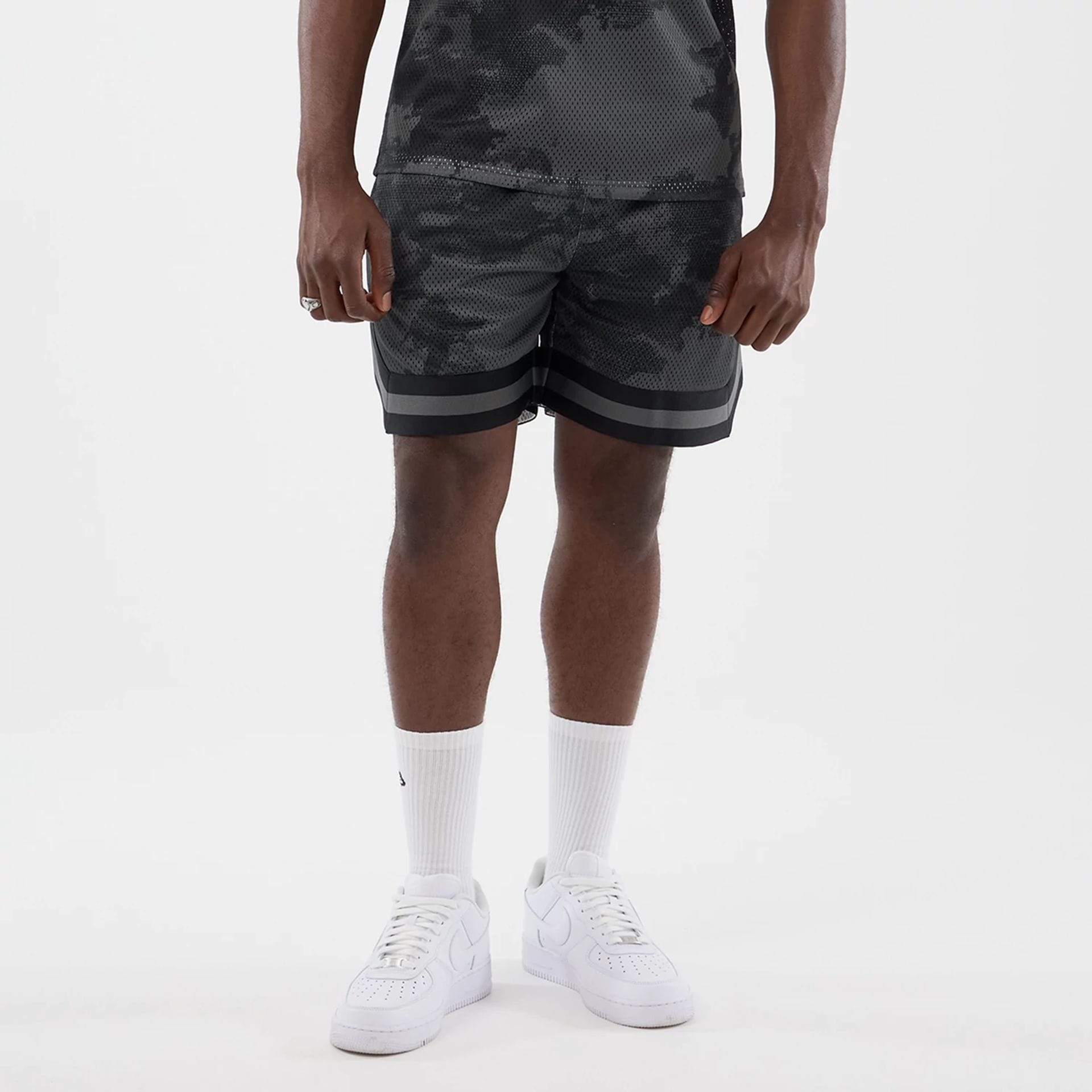 The model is wearing this New Era All Over Print Mesh Shorts in black camo. 1