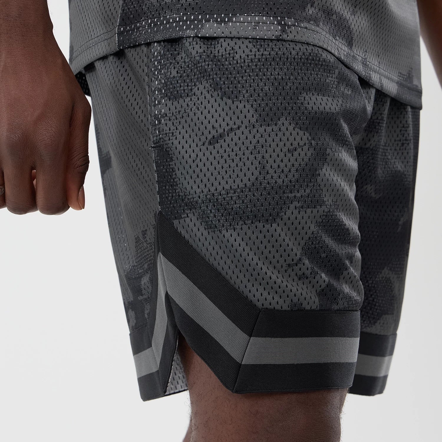 The model is wearing this New Era All Over Print Mesh Shorts in black camo. 3