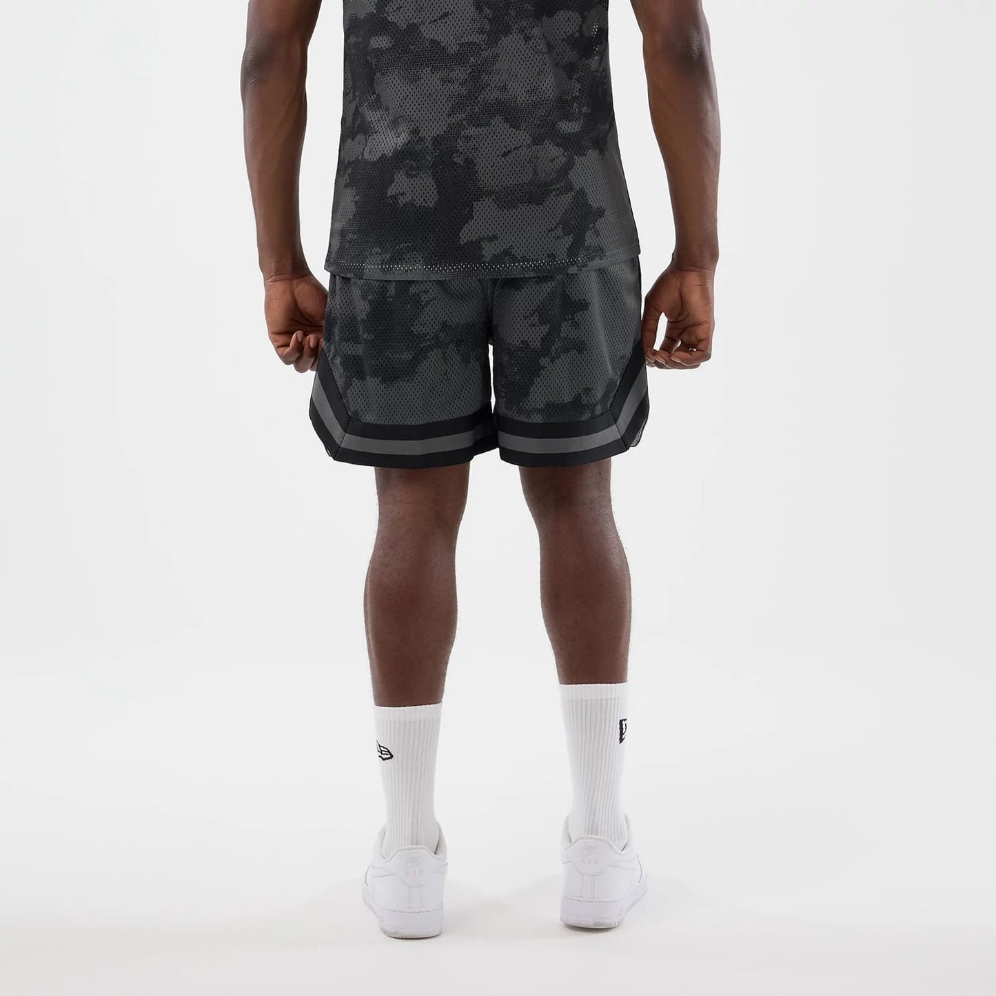 The model is wearing this New Era All Over Print Mesh Shorts in black camo. 2