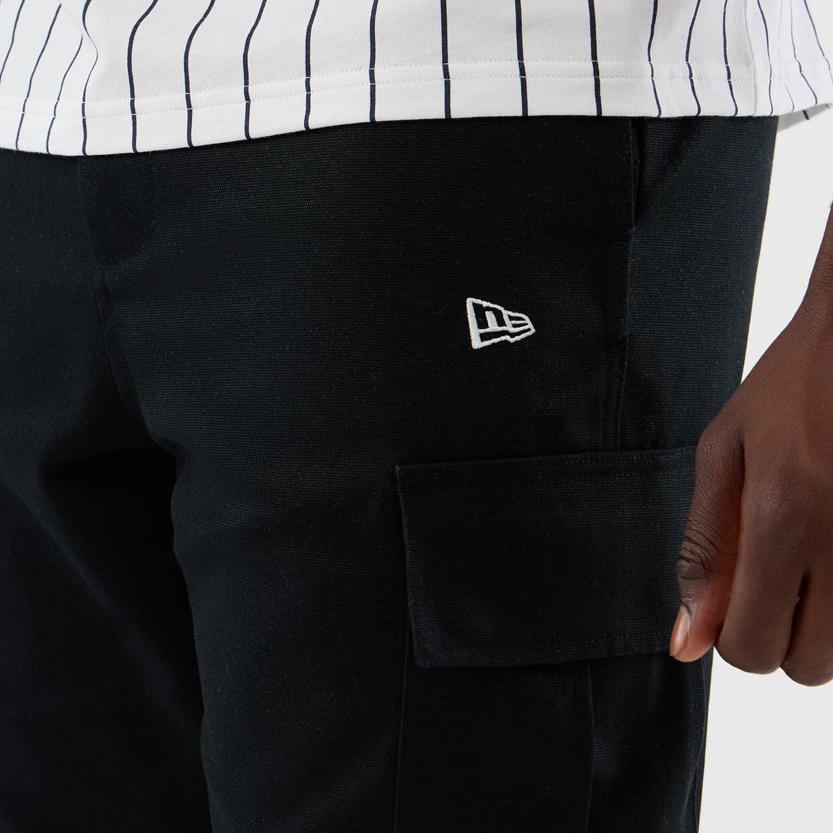 The model is wearing this New Era Cargo Shorts in black. 5