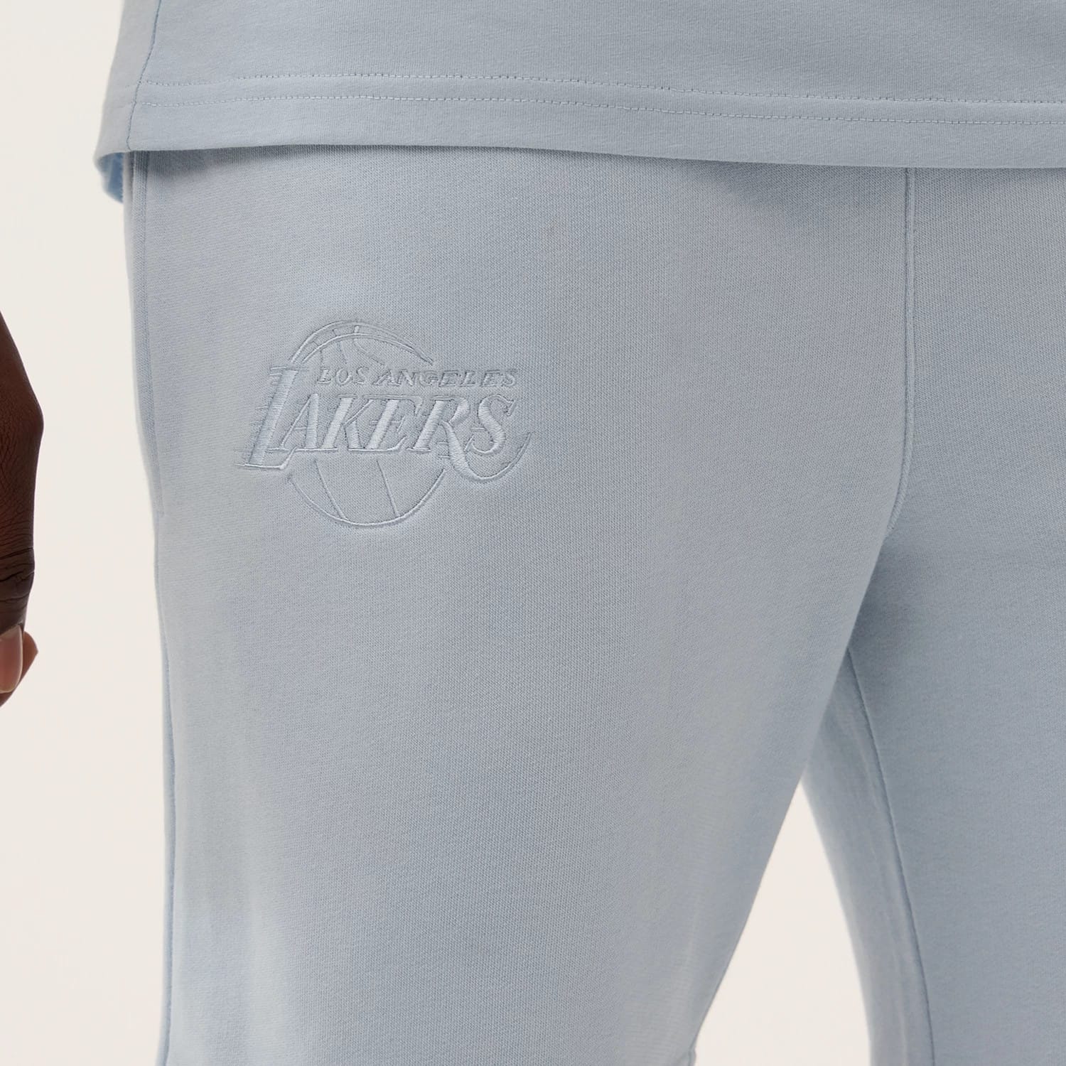 The model is wearing this NBA League Essential LA Lakers Shorts in pastel blue. 3
