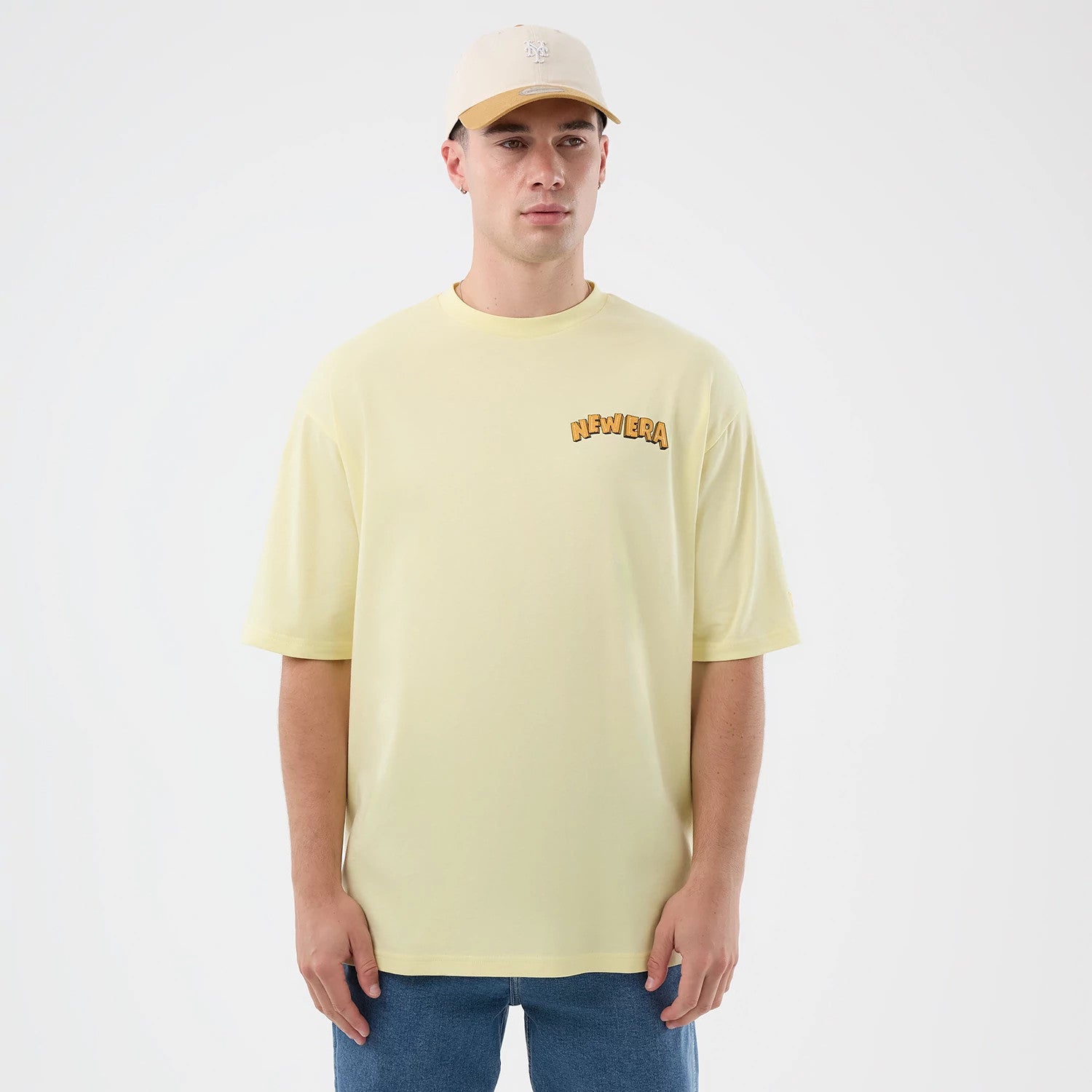 The model is wearing this New Era Fun Beach Party Graphic Oversized T-Shirt in pastel yellow. 3