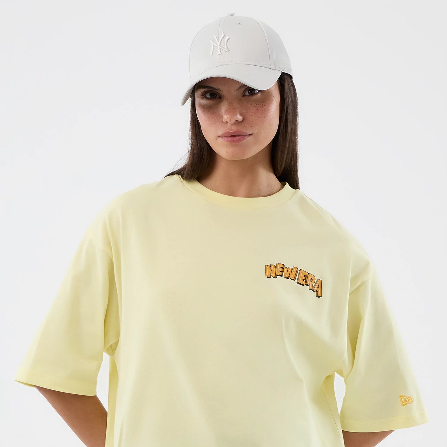 The model is wearing this New Era Fun Beach Party Graphic Oversized T-Shirt in pastel yellow. 7