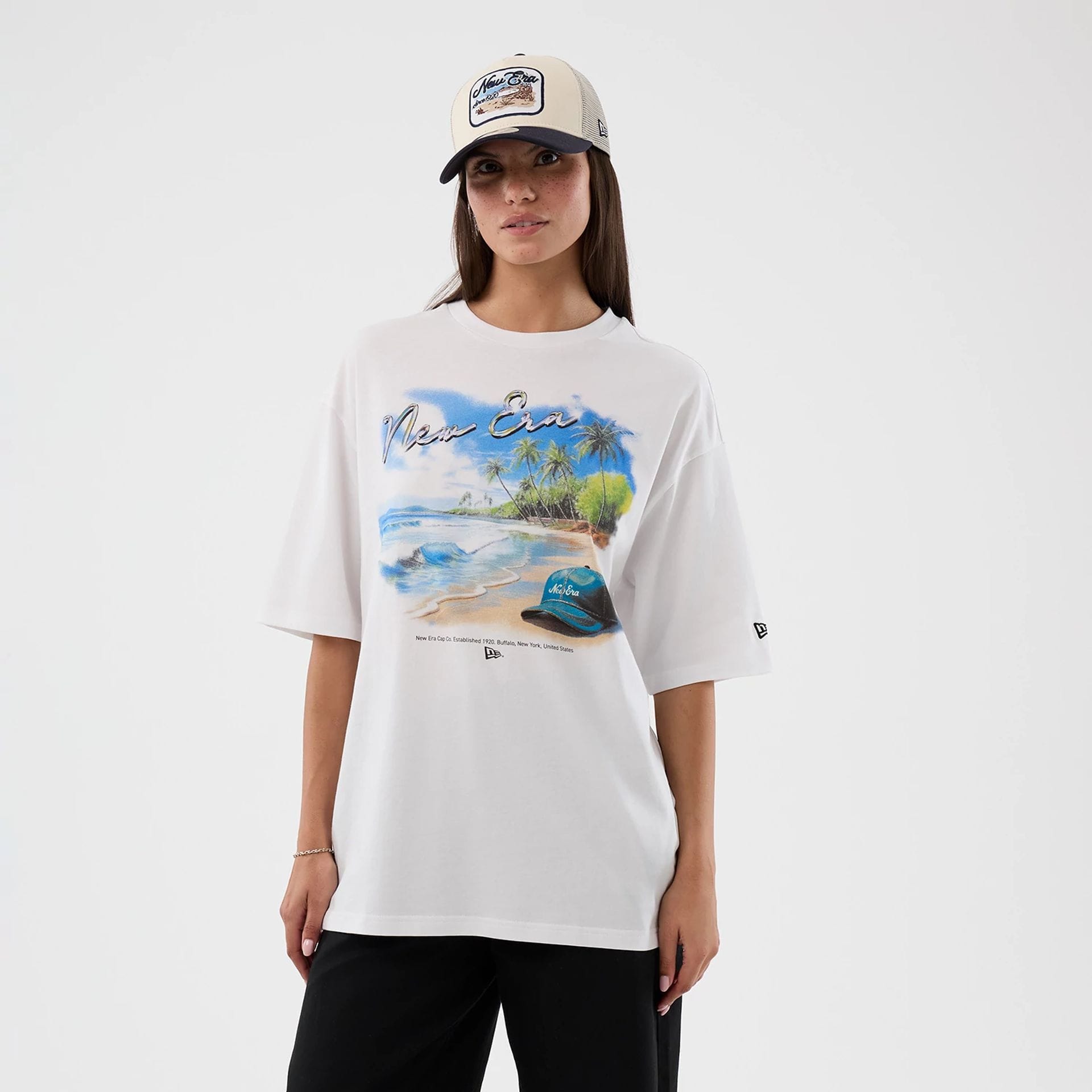 The model is wearing this New Era Beach Graphic Oversized T-Shirt in white. 4