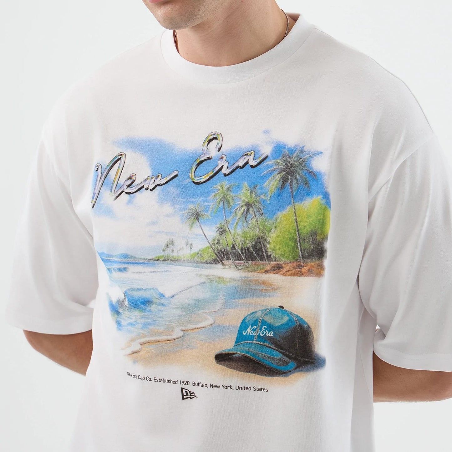 The model is wearing this New Era Beach Graphic Oversized T-Shirt in white. 5