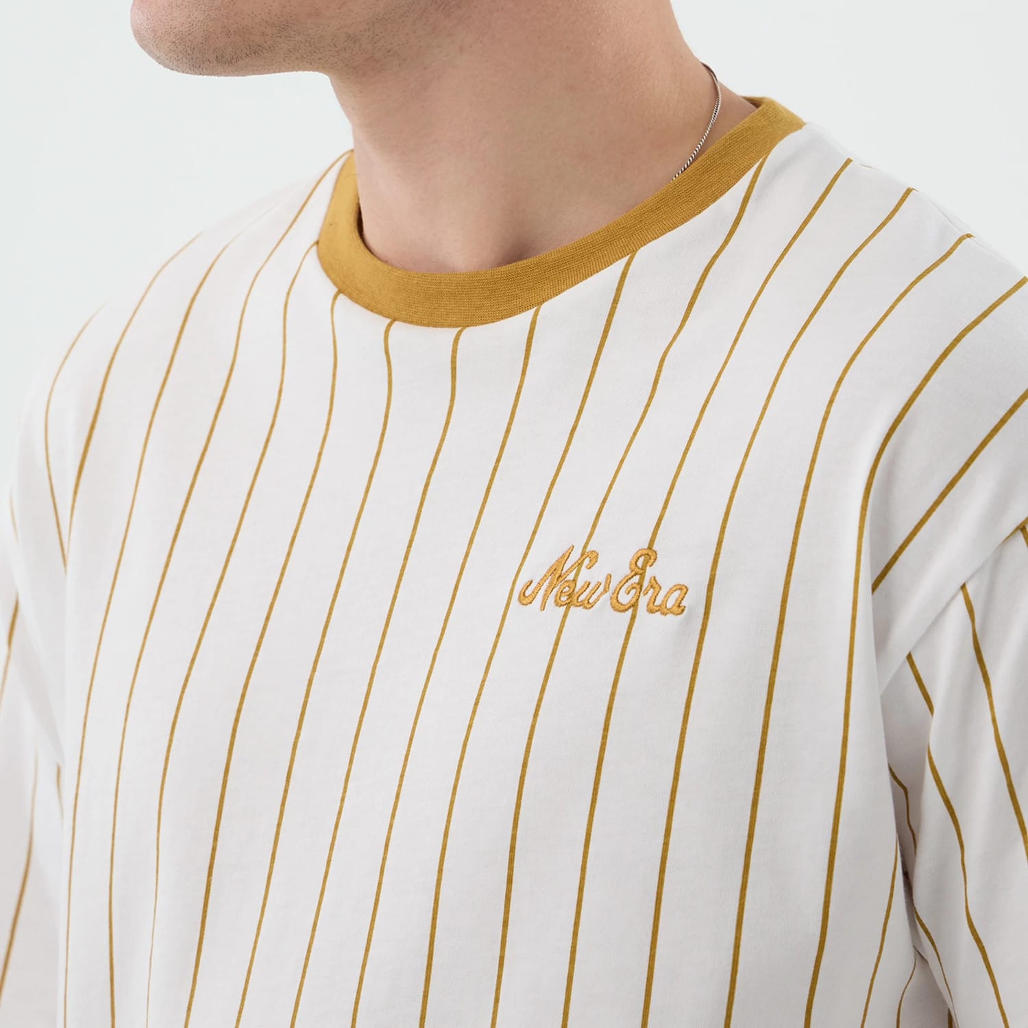 The model is wearing this New Era Pinstripe Oversized T-Shirt in white. 4