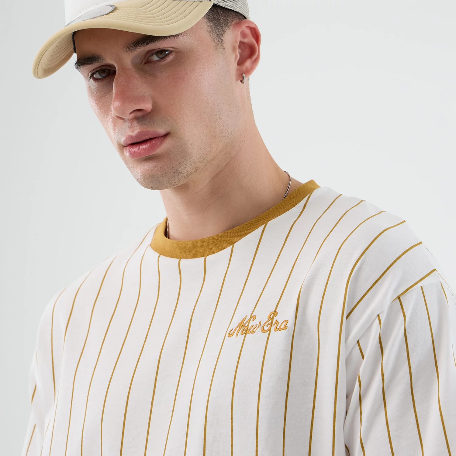 The model is wearing this New Era Pinstripe Oversized T-Shirt in white. 6