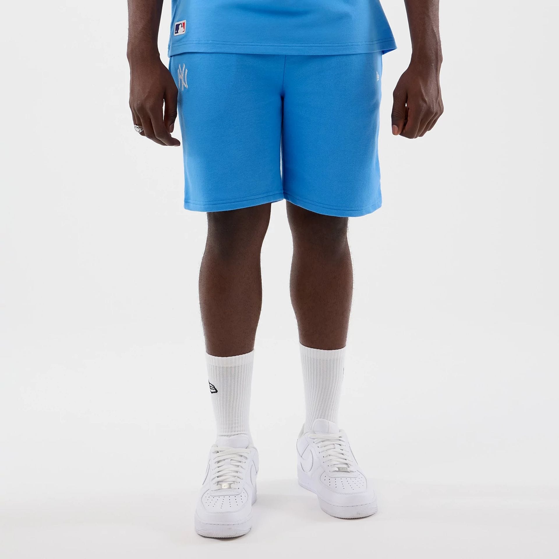 The model is wearing this MLB League Essential New York Yankees Shorts in pastel blue. 1