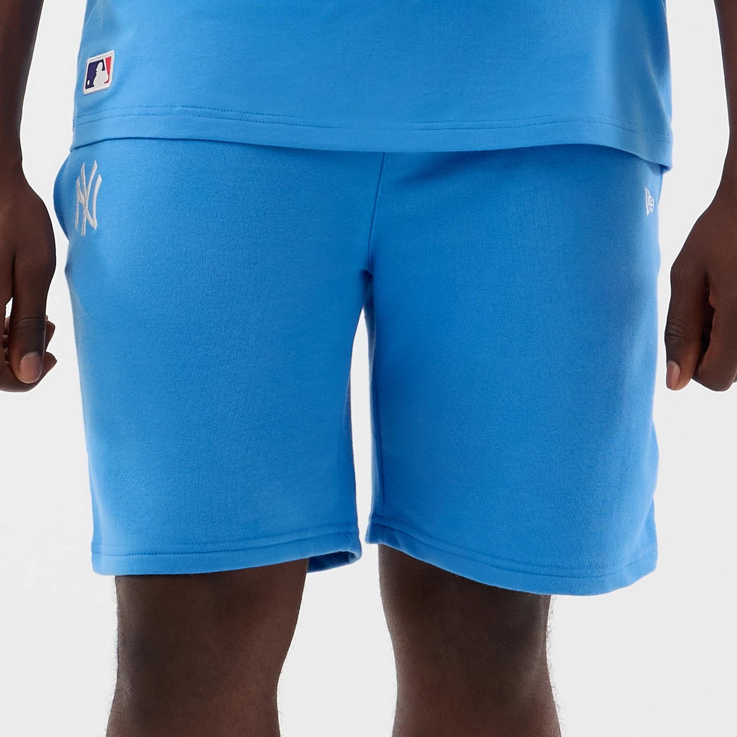 The model is wearing this MLB League Essential New York Yankees Shorts in pastel blue. 7