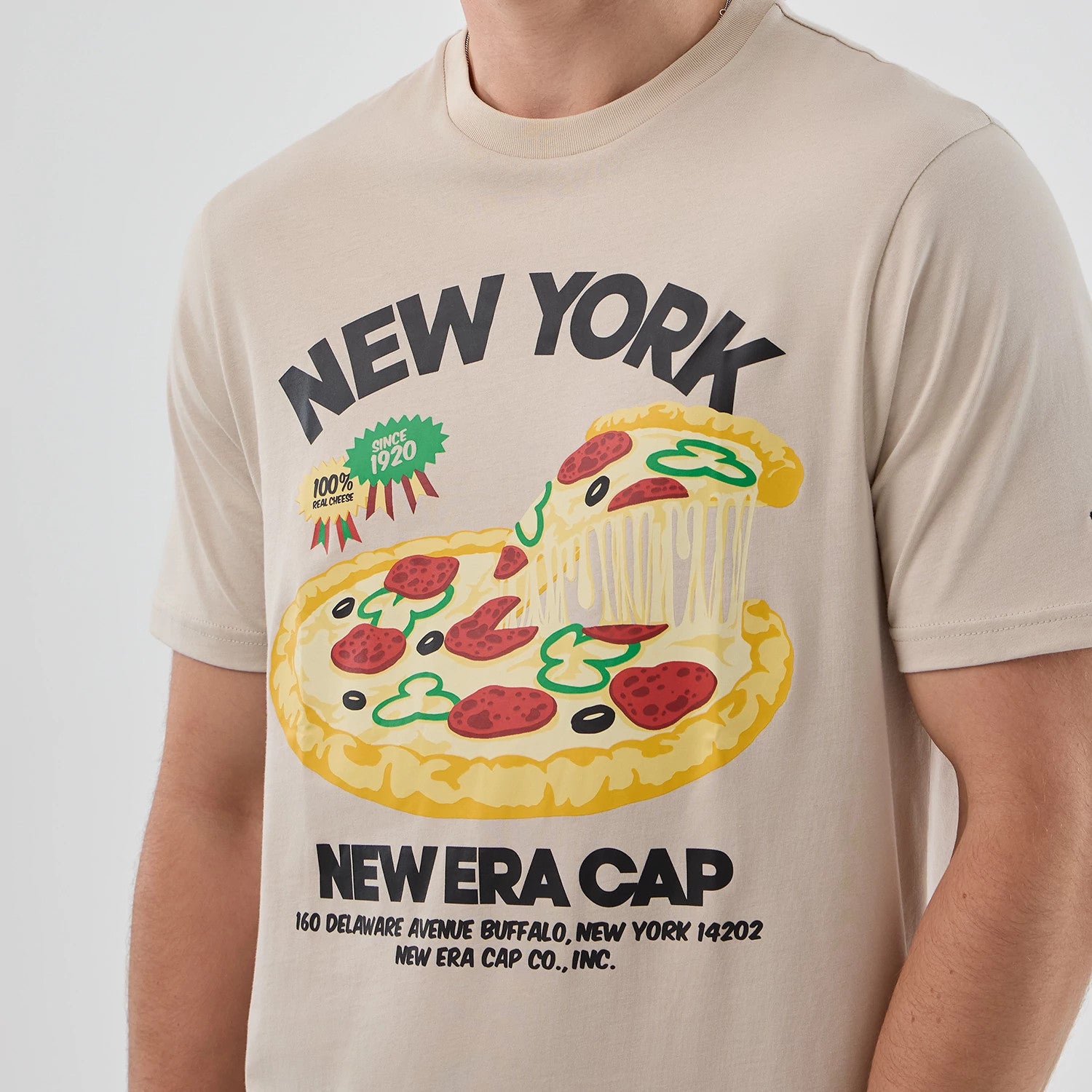 The model is wearing this New Era Pizza Graphic T-Shirt in light beige. 5