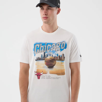New Era Chicago Bulls NBA Beach Graphic White T-Shirt, front view on-model featuring a large basketball and cityscape graphic with 'Chicago' lettering across the chest, an embroidered New Era logo on the sleeve, and a Bulls logo at the bottom left.