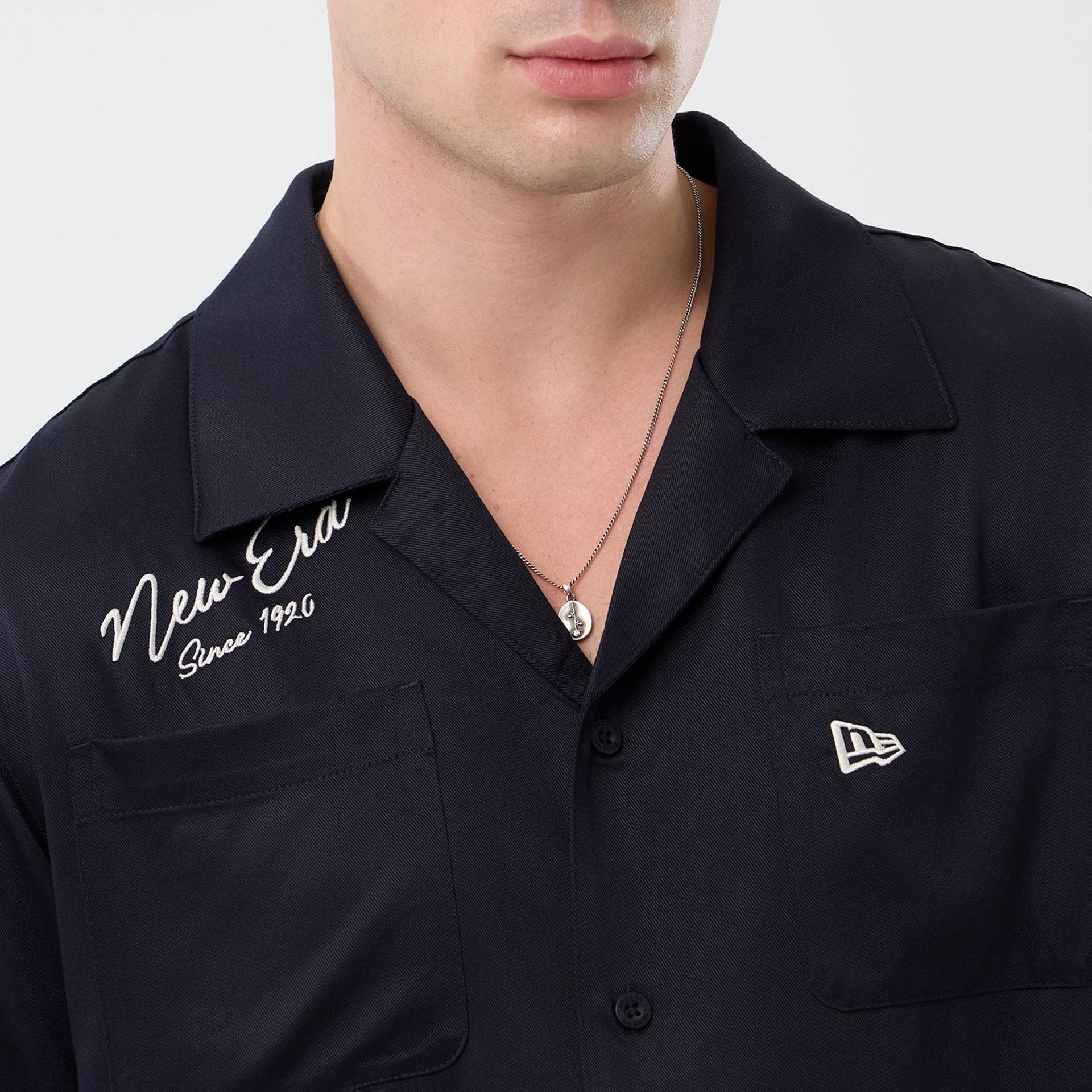 The model is wearing this New Era Graphic Revere Short Sleeve Shirt in navy. 6