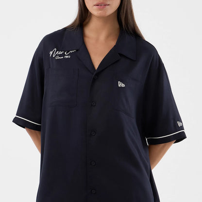 The model is wearing this New Era Graphic Revere Short Sleeve Shirt in navy. 7