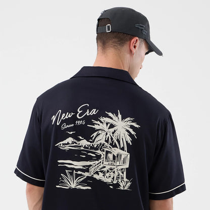 The model is wearing this New Era Graphic Revere Short Sleeve Shirt in navy. 5