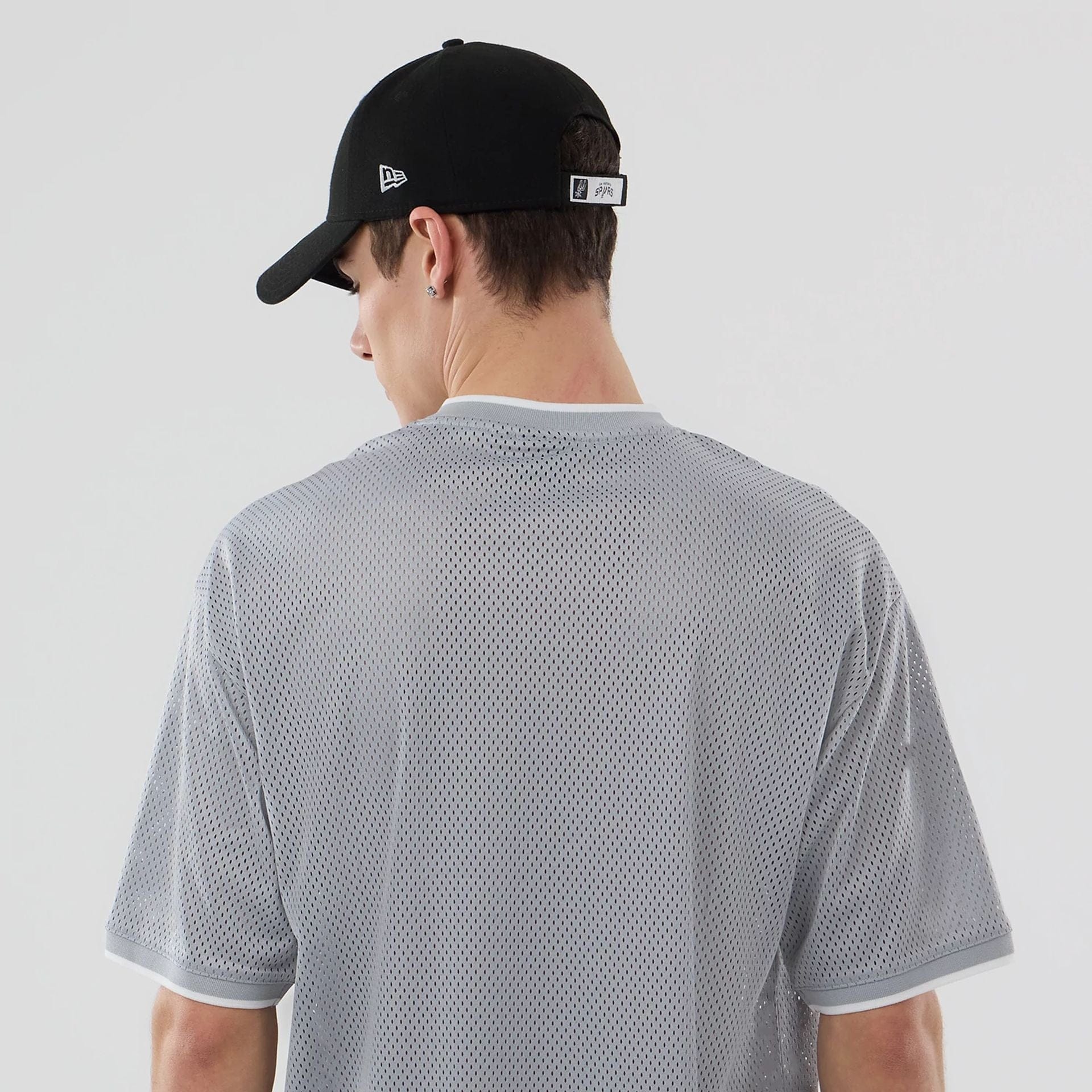 The model is wearing this NBA Mesh San Antonio Spurs Oversized T-Shirt in grey. 7