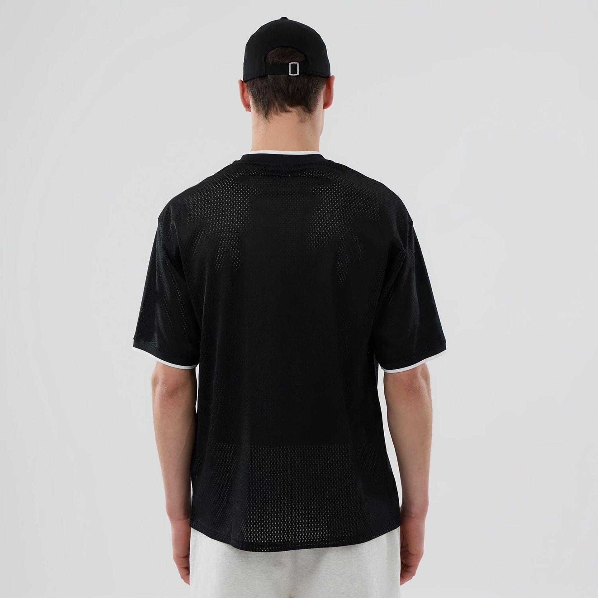 The model is wearing this NBA Mesh Chicago Bulls Oversized T-Shirt in black. 2