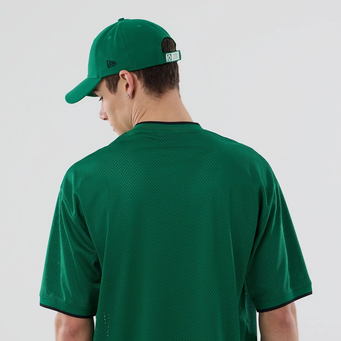 The model is wearing this NBA Mesh Boston Celtics Oversized T-Shirt in green. 7
