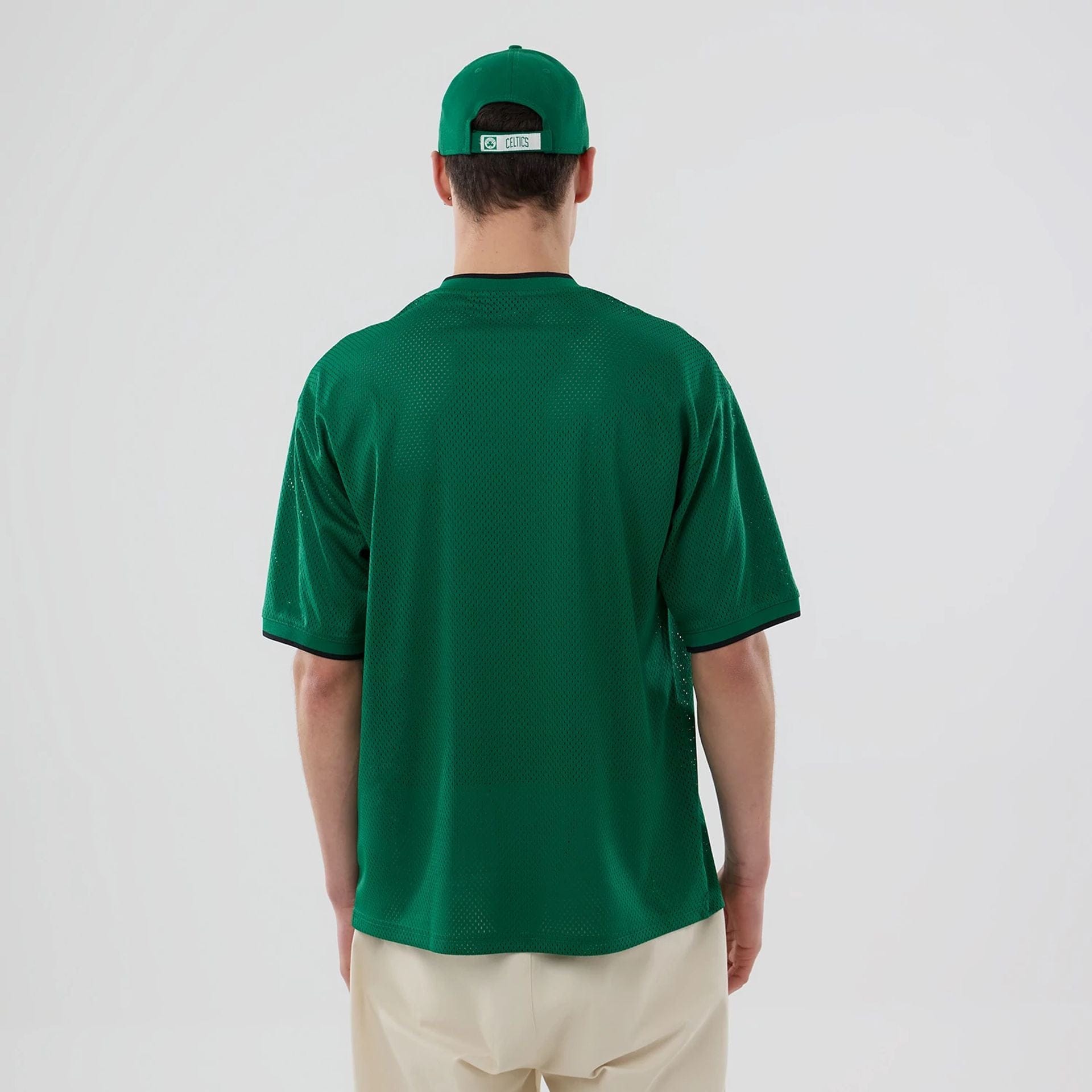 The model is wearing this NBA Mesh Boston Celtics Oversized T-Shirt in green. 2