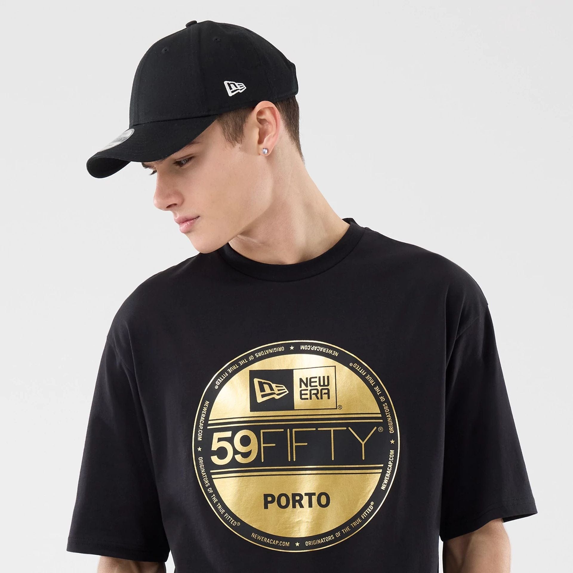 The model is wearing this New Era Sticker Porto Oversized T-Shirt in black. 6