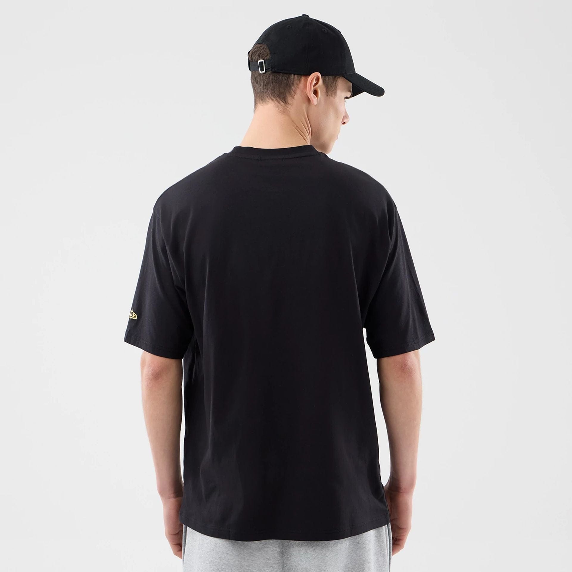 The model is wearing this New Era Sticker Porto Oversized T-Shirt in black. 2