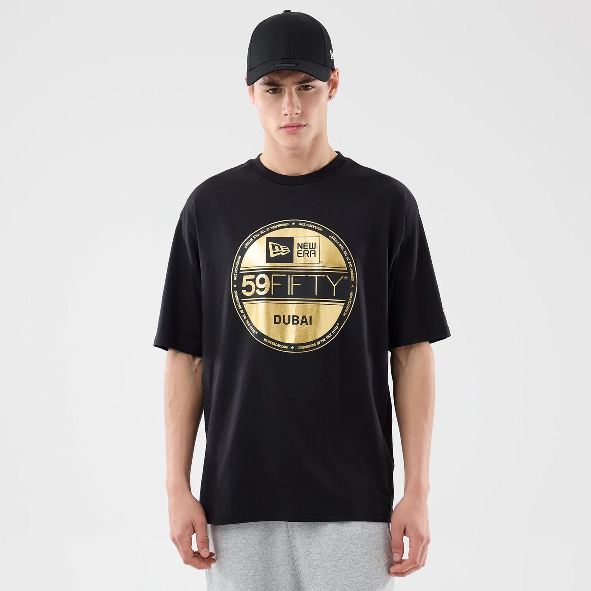 The model is wearing this New Era Sticker Dubai Oversized T-Shirt in black. 1