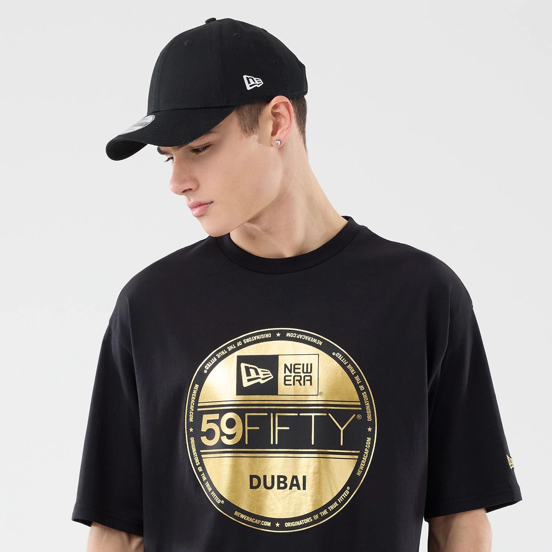 The model is wearing this New Era Sticker Dubai Oversized T-Shirt in black. 6