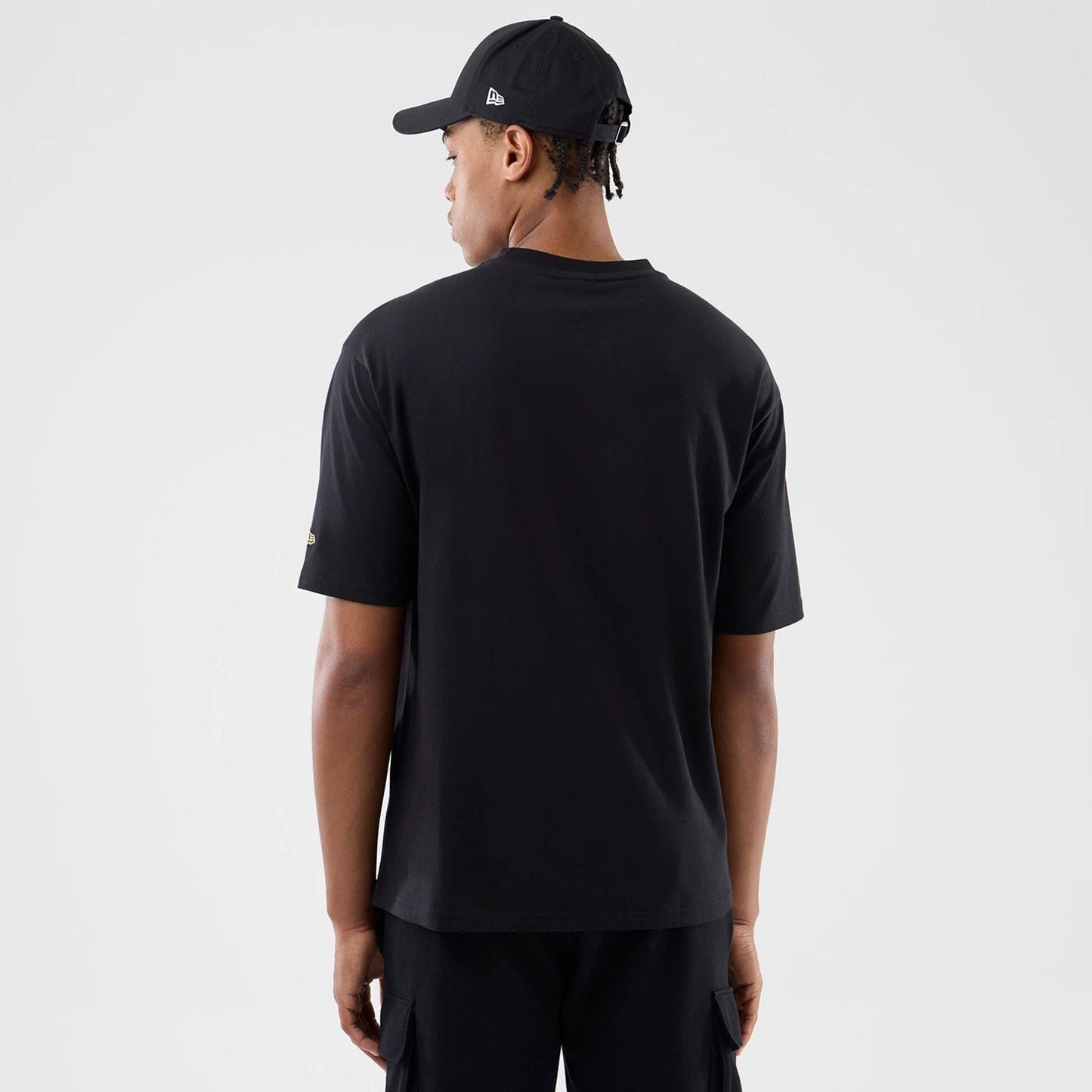 The model is wearing this New Era Sticker Madrid Oversized T-Shirt in black. 2